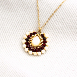 Détail du pendentif — contraste entre nacre lumineuse et grenat profond