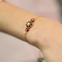 Détail du motif — broderie de perles rouge profond