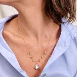3.	Collier Manon en tanzanite porté au creux du décolleté avec une chemise bleu clair.