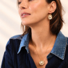 3.	Collier soleil Garance en tanzanite posé sur un tissu rose poudré.