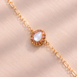 2.	Détail de la goutte de nacre entourée de petites perles roses.